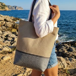 Esta tote bag artesanal combina elegancia, funcionalidad y calidad en un diseño de tamaño mediano, ideal para el día a día. Su silueta cuidada y sus asas cómodas la convierten en un bolso versátil y sofisticado, pensado para acompañarte tanto en jornadas laborales como en momentos más informales. En el exterior incorpora un bolsillo con cremallera, discretamente protegido bajo una pequeña solapa, aportando seguridad sin renunciar al diseño. El interior, completamente forrado, se cierra mediante un clip de imán y está organizado para que todo tenga su lugar: un bolsillo interior con cremallera, otro bolsillo adicional también con cremallera y dos bolsillos abiertos, perfectos para tener a mano los objetos esenciales. Un bolso hecho a mano, con atención al detalle y materiales de calidad, pensado para durar y para disfrutarlo cada día