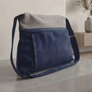 Bossa Bandolera 2-en-1: Elegància i Funcionalitat Diària Aquesta bossa de mà destaca per la seva versatilitat i un disseny compacte i modern. Gràcies a la seva nansa adaptable, la pots portar còmodament sota el braç per a un estil més formal o creuada com a bandolera per a una total llibertat de moviments en el teu dia a dia. Disseny Frontal amb Detalls Pràctics Butxaca Discreta: A la part frontal, la bossa incorpora una cremallera vertical protegida sota una petita solapa. Aquest detall no només aporta un toc estètic diferenciat, sinó que és ideal per guardar objectes petits que necessites tenir a mà de forma segura. Interior Optimitzat i Segur L'accés principal es realitza a través d'una cremallera central que garanteix la protecció de totes les teves pertinences: Organització Interna: A l'interior trobaràs una butxaca amb cremallera addicional, perfecta per mantenir l'ordre i separar els objectes més valuosos o delicats. Sistema per a Claus: Inclou una pràctica cinta amb mosquetó, pensada perquè trobis les claus a l'instant sense haver de buscar-les per tota la bossa. Comoditat Adaptable La seva estructura lleugera i la facilitat per canviar la posició de la nansa fan d'aquesta bossa el complement ideal per a qualsevol ocasió, combinant la seguretat d'una bossa tancada amb la practicitat d'una bandolera urbana.