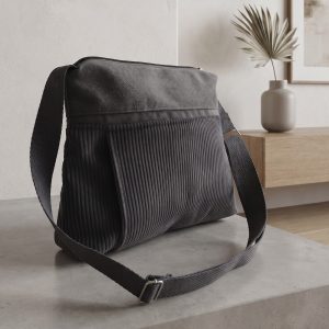 Bossa Bandolera 2-en-1: Elegància i Funcionalitat Diària Aquesta bossa de mà destaca per la seva versatilitat i un disseny compacte i modern. Gràcies a la seva nansa adaptable, la pots portar còmodament sota el braç per a un estil més formal o creuada com a bandolera per a una total llibertat de moviments en el teu dia a dia. Disseny Frontal amb Detalls Pràctics Butxaca Discreta: A la part frontal, la bossa incorpora una cremallera vertical protegida sota una petita solapa. Aquest detall no només aporta un toc estètic diferenciat, sinó que és ideal per guardar objectes petits que necessites tenir a mà de forma segura. Interior Optimitzat i Segur L'accés principal es realitza a través d'una cremallera central que garanteix la protecció de totes les teves pertinences: Organització Interna: A l'interior trobaràs una butxaca amb cremallera addicional, perfecta per mantenir l'ordre i separar els objectes més valuosos o delicats. Sistema per a Claus: Inclou una pràctica cinta amb mosquetó, pensada perquè trobis les claus a l'instant sense haver de buscar-les per tota la bossa. Comoditat Adaptable La seva estructura lleugera i la facilitat per canviar la posició de la nansa fan d'aquesta bossa el complement ideal per a qualsevol ocasió, combinant la seguretat d'una bossa tancada amb la practicitat d'una bandolera urbana.